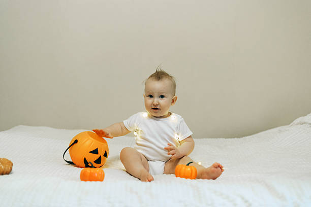 istock Baby Playing with Halloween Decorations and Lights 2241477147