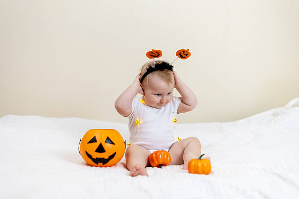 istock Cute Baby with Pumpkin Headband and Halloween Decor 2241477396