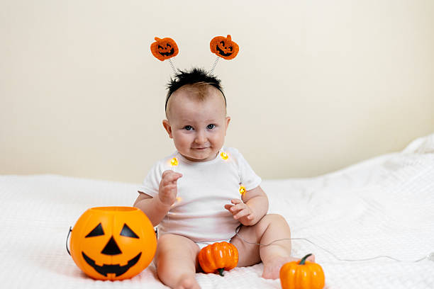 istock Cute Baby with Pumpkin Headband and Halloween Decor 2241477459
