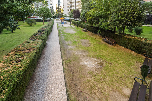 istock Gardens with hedges, trees and a children's playground in a communal square 2241479482