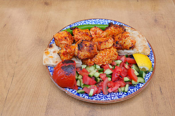 A plate of grilled chicken skewers served with rice and salad.