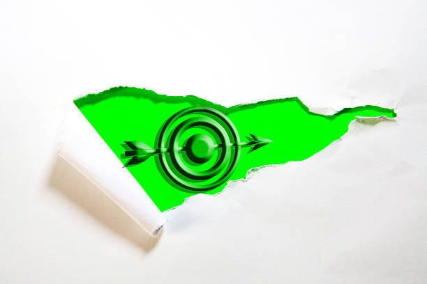 Torn paper with green target on the white background, business concept