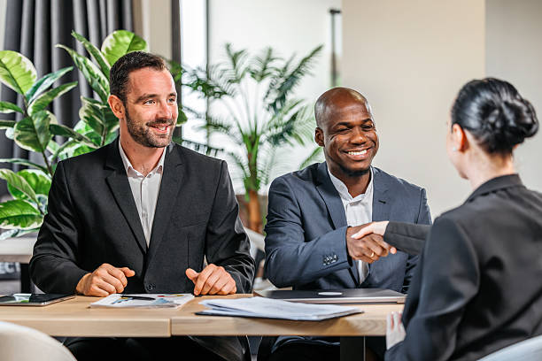 istock Two business people shaking hands in a modern office 2241480705