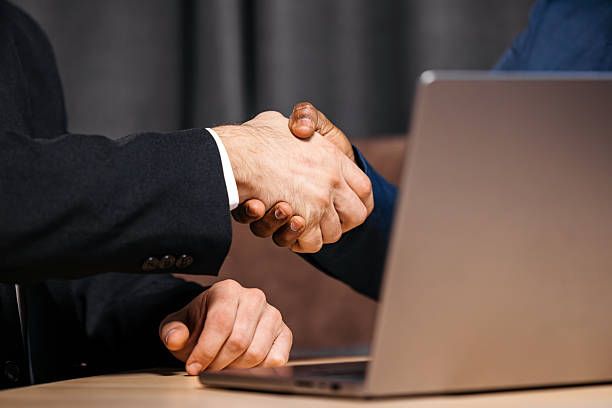 istock Two business people shaking hands in a modern office 2241480833