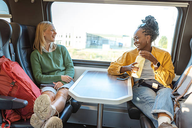 istock Friends share a laugh on a train carriage with a table, enjoying travel and conversation 2241482124