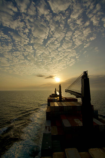 A container ship at sea, view from the bridge wings of the ship with morning sun in the background