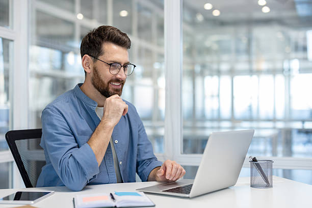 istock A businessman is focused on his laptop, planning his next steps with a smile. 2241485282