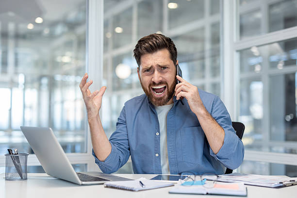 istock Stressed businessman yelling on phone in office 2241488058