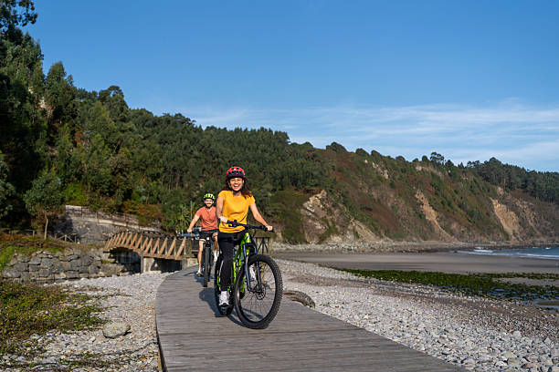 istock Couple exploring coastline, riding e-bikes on boardwalk, enjoying active leisure and travel near beach 2241488103