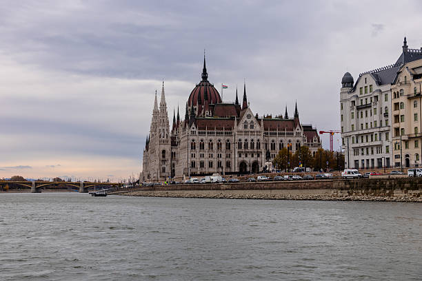 Hungarian Parliament Building in Budapest, Hungary viewed from the water with the Danube River in the foreground.