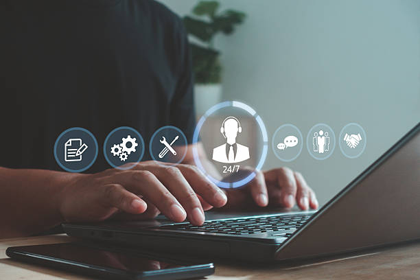 istock Businessman using laptop with virtual icons of customer support, service tools and communication. 24/7 online support, technical assistance and customer relationship management in digital business. 2241489797
