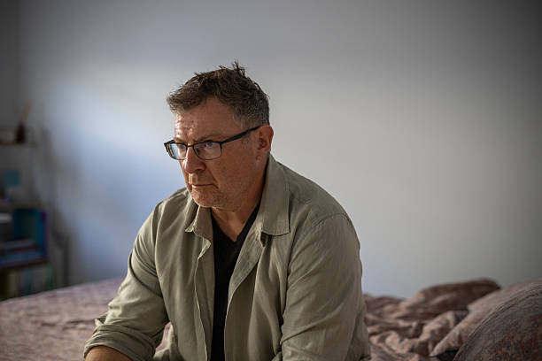 istock Depressed overweight man sitting on the bed 2241491268