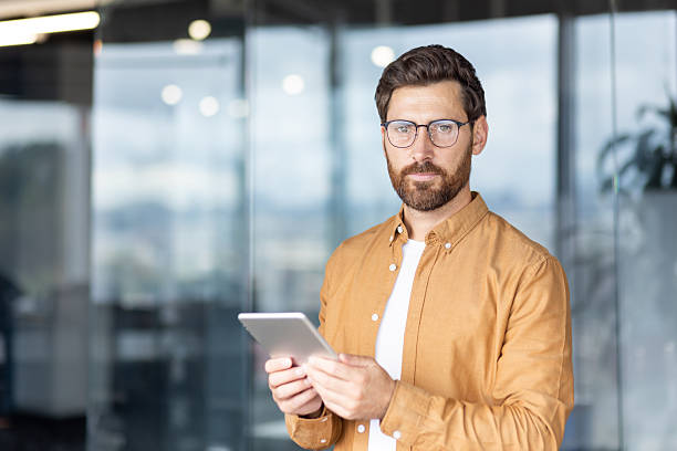 istock Modern businessman using tablet in contemporary office 2241493177