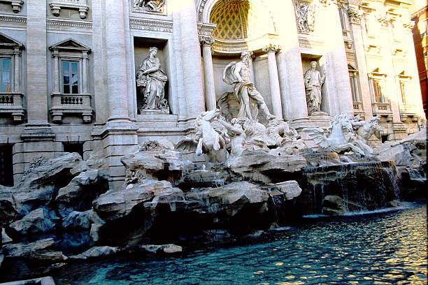 Slide photograph from 2002 capturing the Trevi Fountain (Fontana di Trevi) in Rome, Italy—one of the world’s most iconic Baroque landmarks. Water cascades dramatically into the basin below, emphasizing the fountain’s dynamic sculptural energy. The analog film texture adds nostalgic depth, making this visual ideal for editorial, travel, historical, and mythological-themed creative use. A timeless portrayal of Rome’s artistic and cultural splendor.