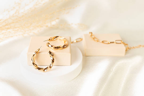 istock Golden earrings with decor on textile background 2241497083