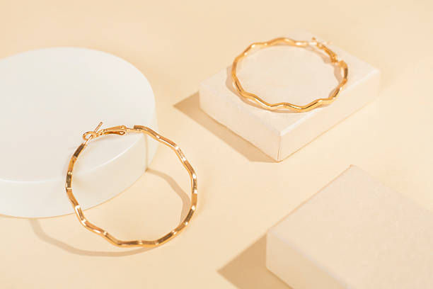 istock Golden earrings with decor on color background 2241497085