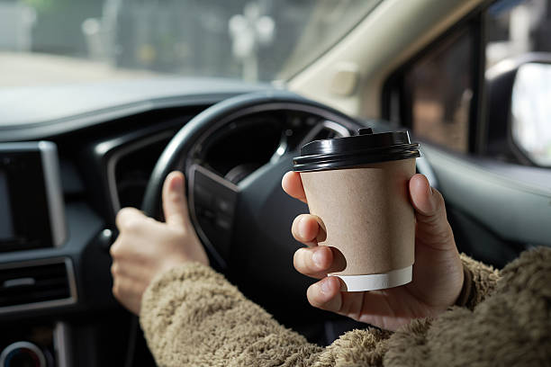 istock Man is drinking hot coffee in the car before going to work at the office every time. 2241497748