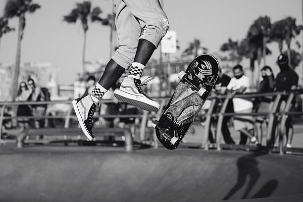 Skateboarder performing a maneuver called a frontside feeble grind at a skate park.