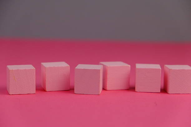istock flat lay of a blank wooden cube for text space. Educational and financial concept with text space on pink background. 2241501202