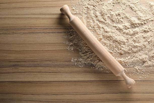 children's hands, the boy kneads the dough, rolls it out, flour is on the table, in the apartment, she makes pastries herself