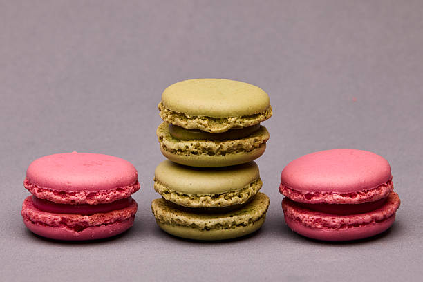istock Three macarons pink green and yellow on gray background 2241503591