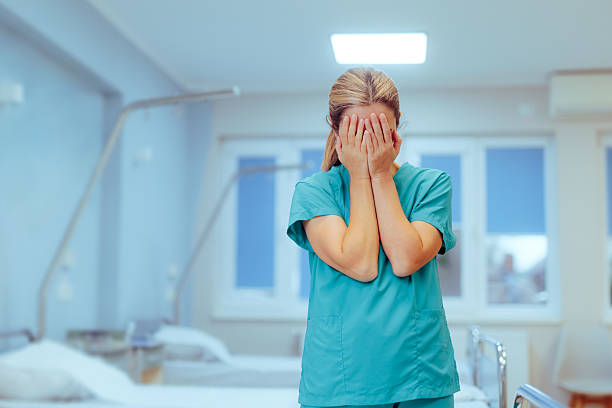 istock Sad Unhappy Nurse feeling Burnout in a Hospital 2241508142