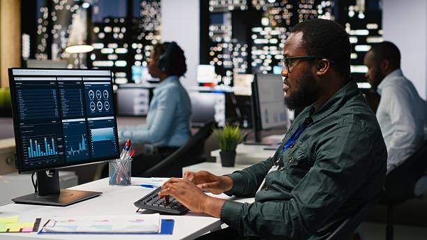 istock Office worker reviewing KPI metrics on monitor and analytics on desktop 2241511821