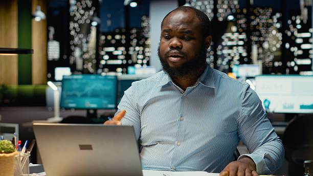 istock Black businessman engaging in online video call from dark office 2241519477