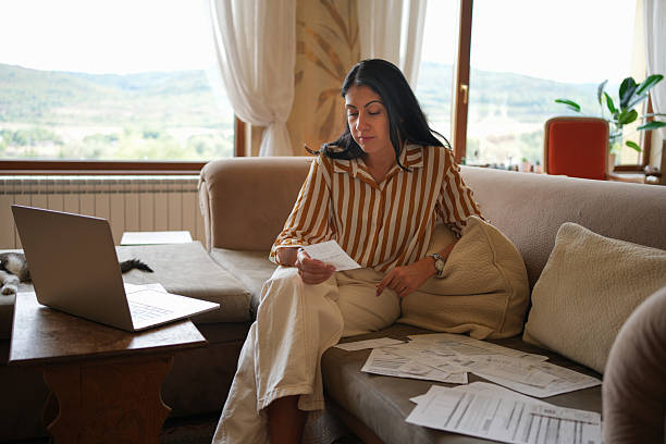 istock Home Finances. Woman Making Domestic Budget & Paying Bills Using Laptop 2241519719