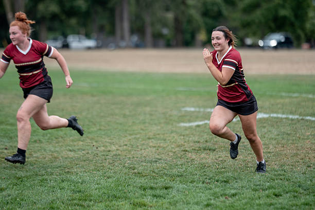 istock Two Female Athletes Run Across Grass Field During Rugby Practice 2241519917