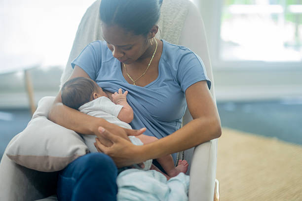 istock Breastfeeding Mother and Newborn Baby Share Tender Bond in Cozy Home Setting 2241520005