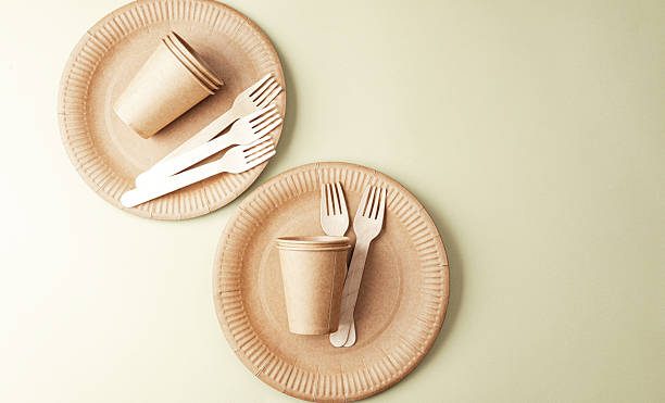 istock Sustainable tableware with eco paper cups and forks on green background minimalist concept 2241520929
