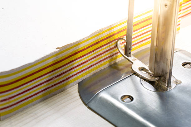 Close-up of a Sewing Machine Stitching Striped Fabric