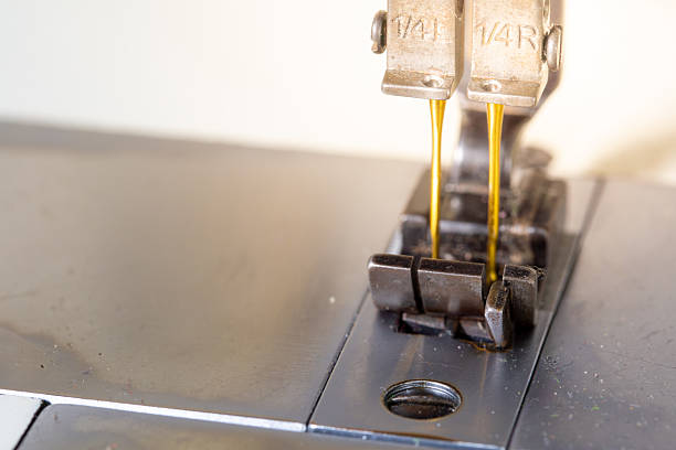 Extreme close-up of a sewing machine needle in motion while stitching.