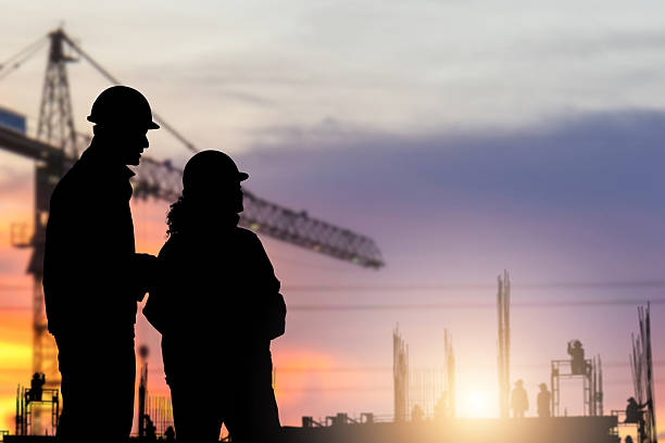 istock Silhouette of Engineer and foreman worker checking project at building site background, construction site at sunset in evening time 2241526274