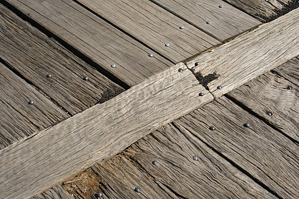 Old weathered gray wooden board floor on a sunny day.