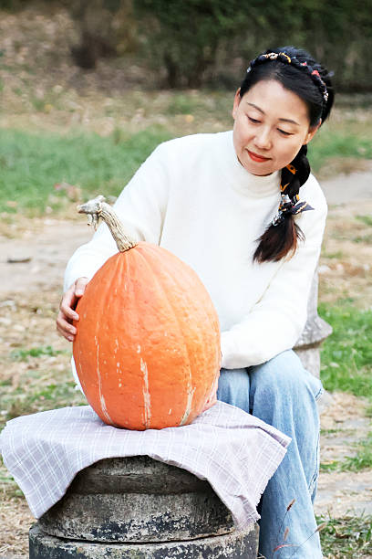 istock A young Asian woman and a pumpkin 2241536474