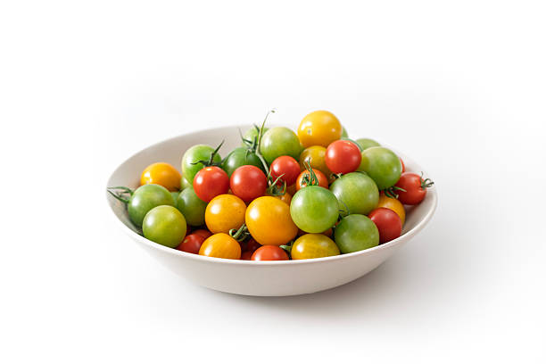 Bowl of colorful cherry tomatoes on white background