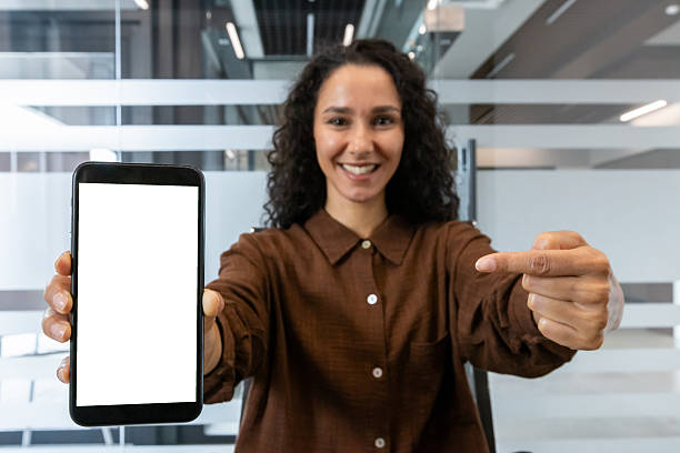 istock Woman presenting smartphone blank screen in modern office 2241541071