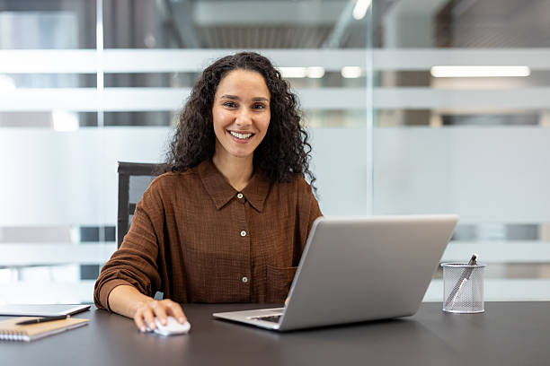 istock Businesswoman smiling while working on laptop in modern office 2241546872