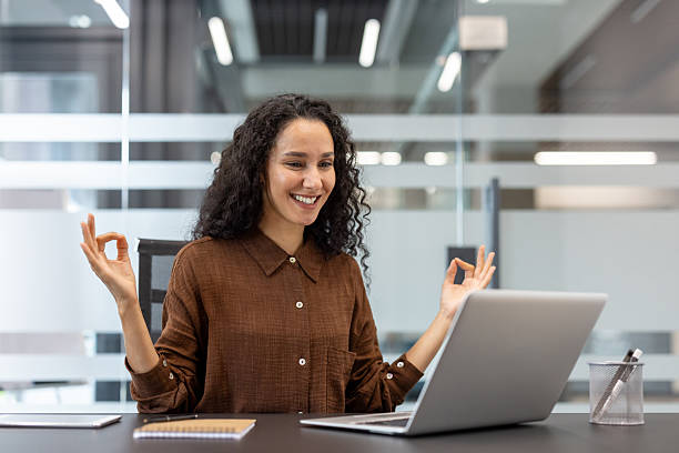 istock Businesswoman meditating with laptop finding peace at work 2241547207