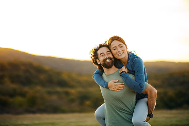 istock Happy couple enjoying piggyback ride during sunset 2241548581