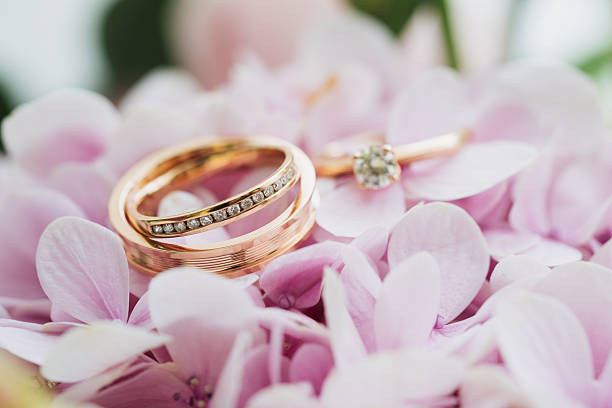 Macro shot highlighting engraved gold rings and a sparkling diamond. Concept of love, commitment, proposal, and elegance. Solitaire diamond ring