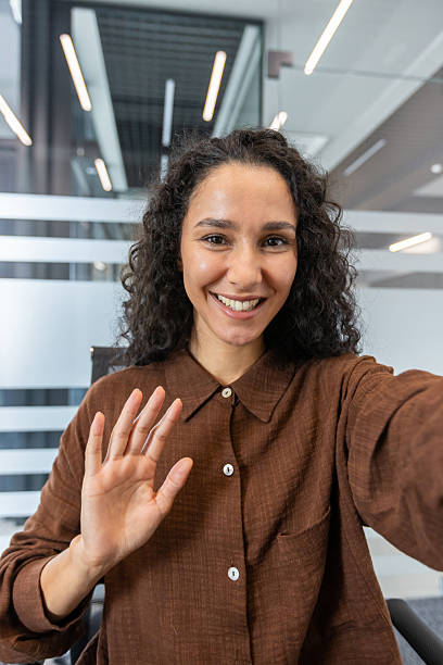 istock Woman waving hand during video call in office 2241550333