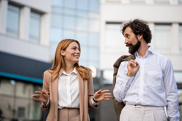 istock Businesspeople talking and walking outside office building 2241551041