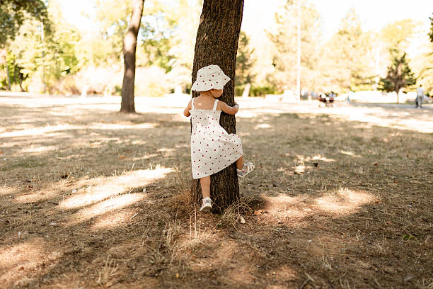 Little girl walks through the park on a sunny day, exploring nature and enjoying outdoor time.