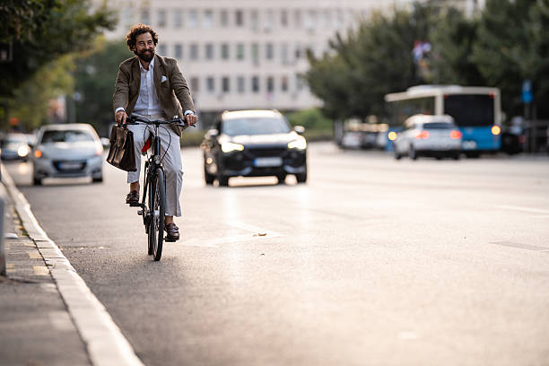 istock Businessman riding bicycle in city traffic during commute 2241551874