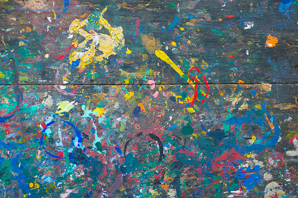 istock Colorful splashes of paint on old wooden surface. Abstract background 2241553528