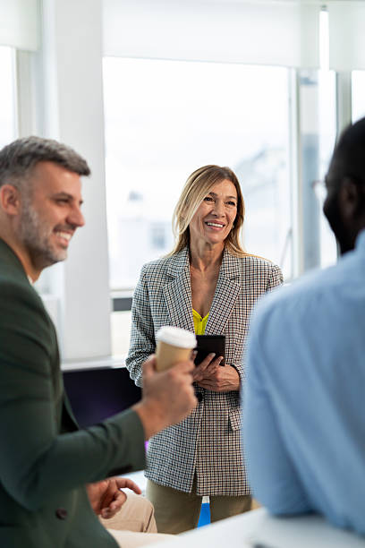 istock Diverse business people smiling and talking in a modern office 2241554412