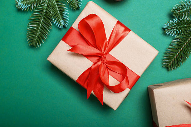 istock Christmas Gift Boxes with Red Ribbons on Green Festive Background 2241554560